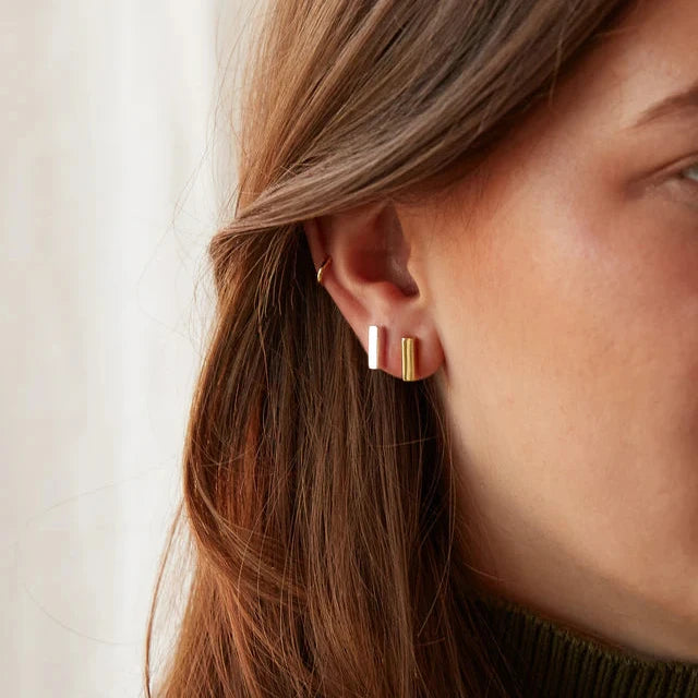 Pair of minimalist rectangular stud earrings; one gold, one silver.