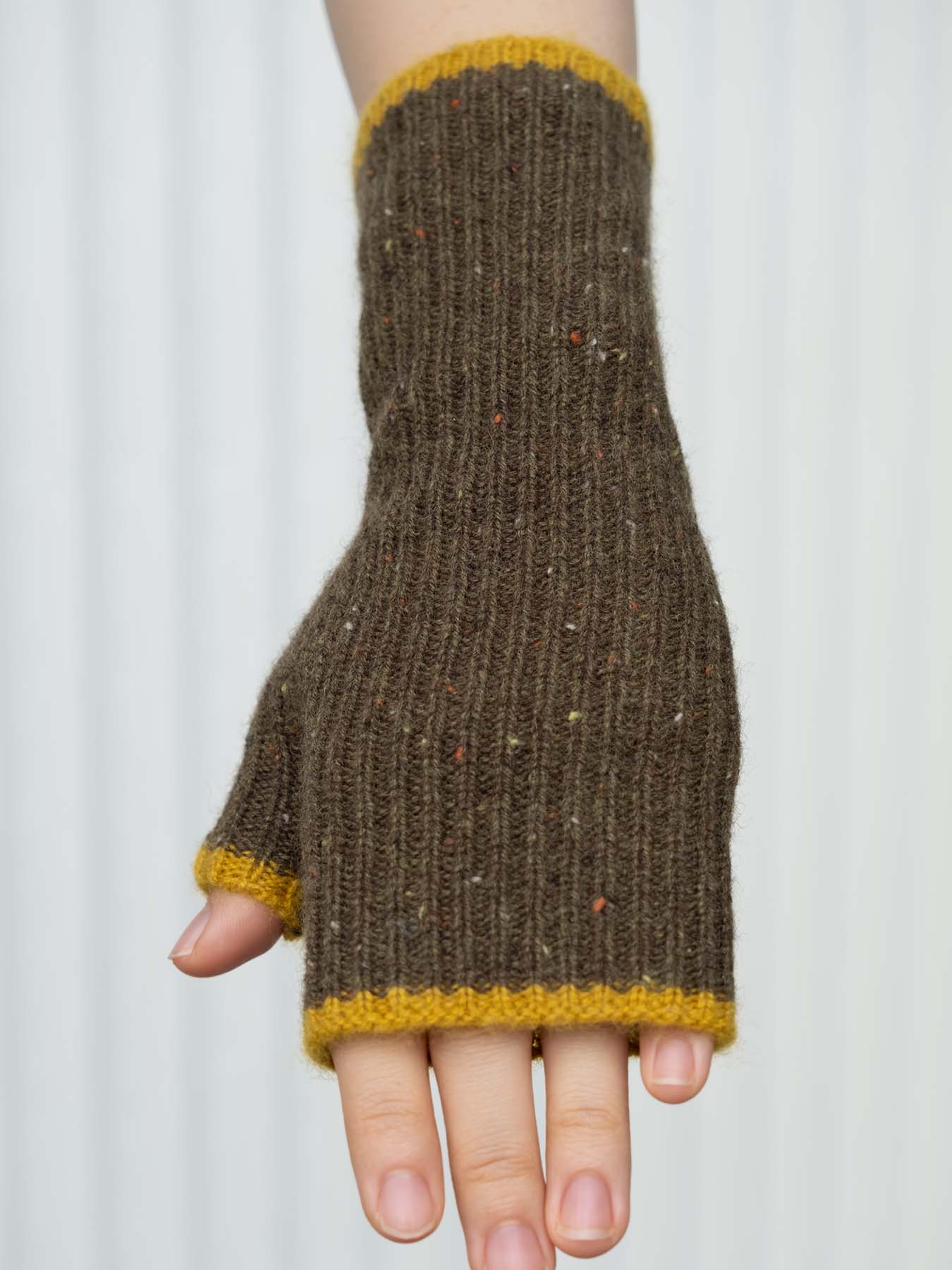 Brown knitted fingerless glove with yellow trim on a white background