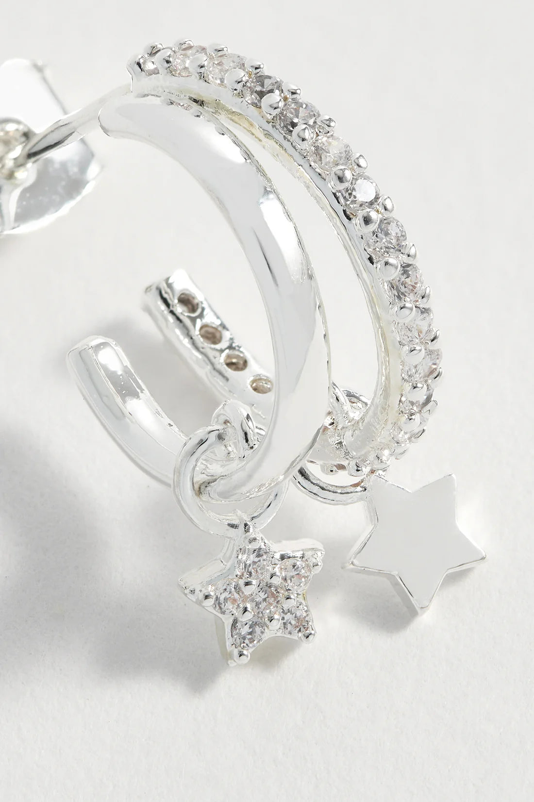 Silver double hoop earrings with clear cubic zirconia accents and dangling star charms.