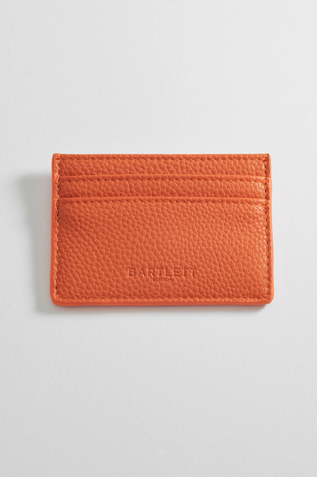 Orange leather cardholder with three card slots and embossed "Barlett London" logo.