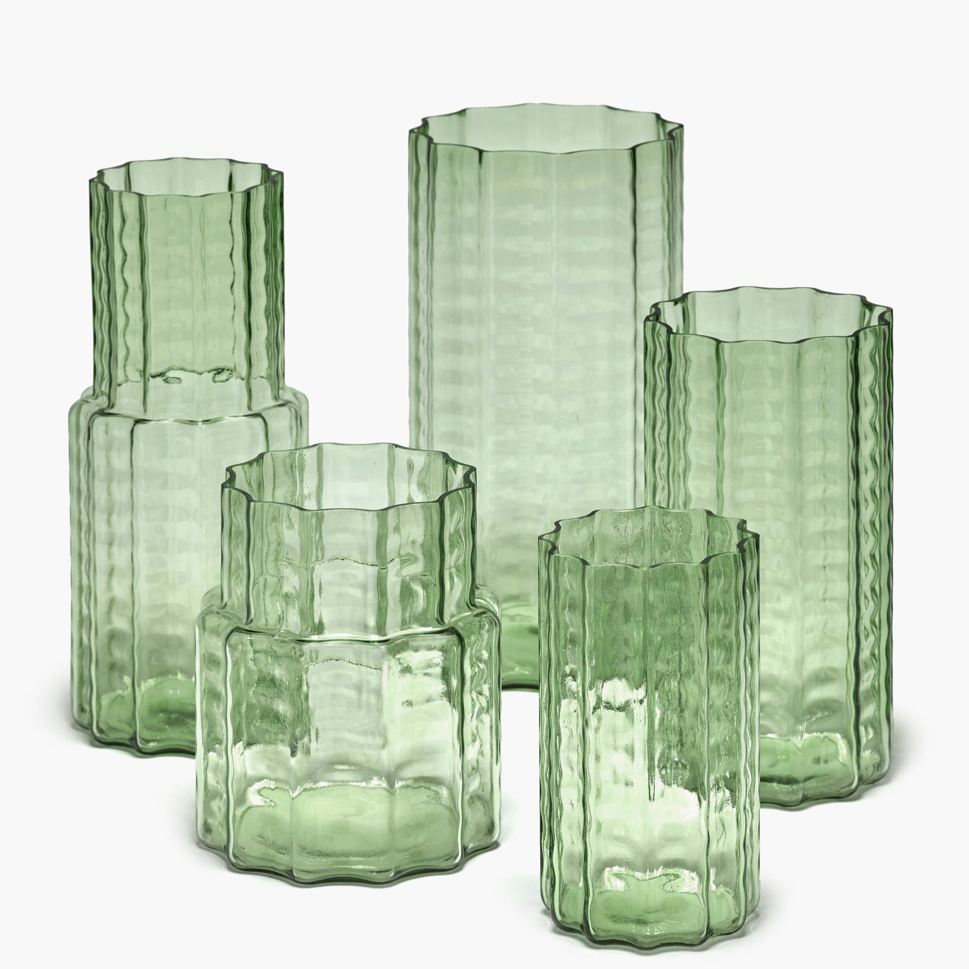 Set of four light green glass vases; each with a textured, faceted design and varying heights.