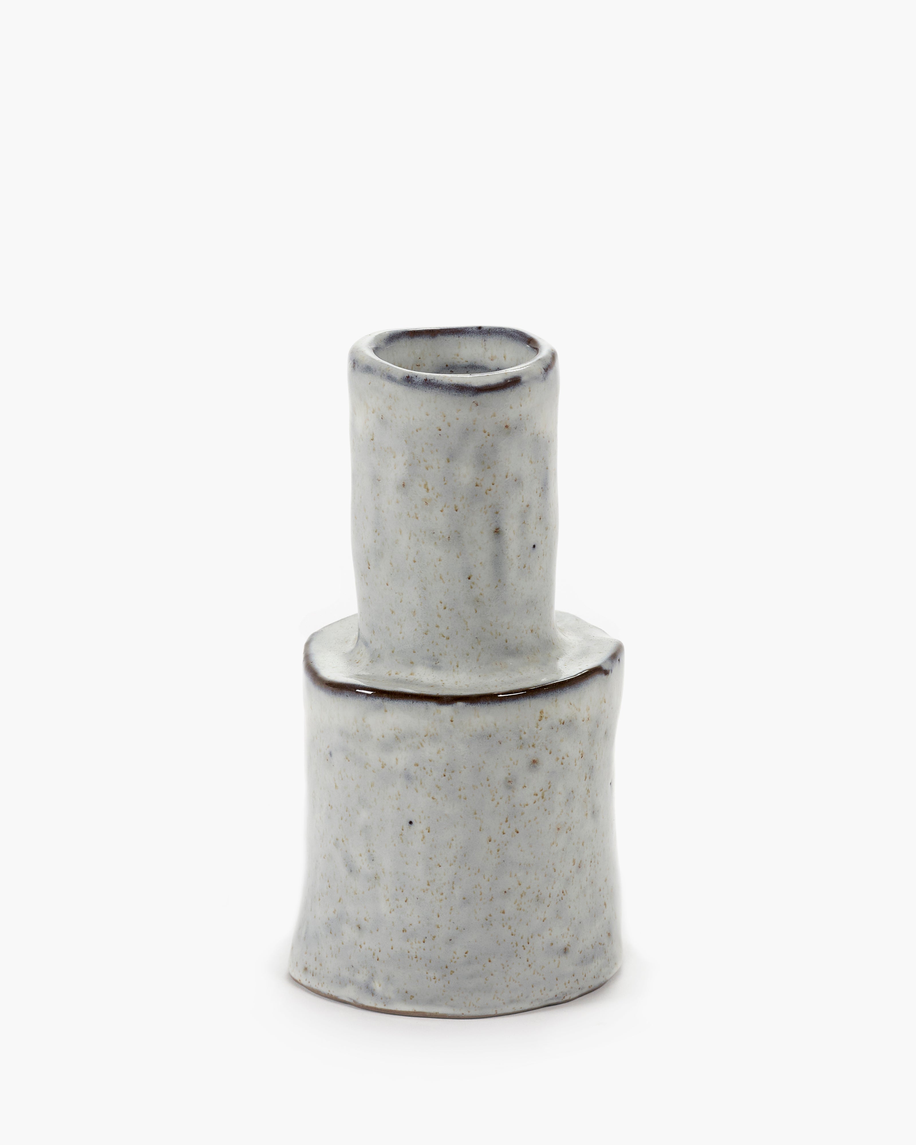 A small, light grey ceramic vase with a speckled texture and dark brown rim.