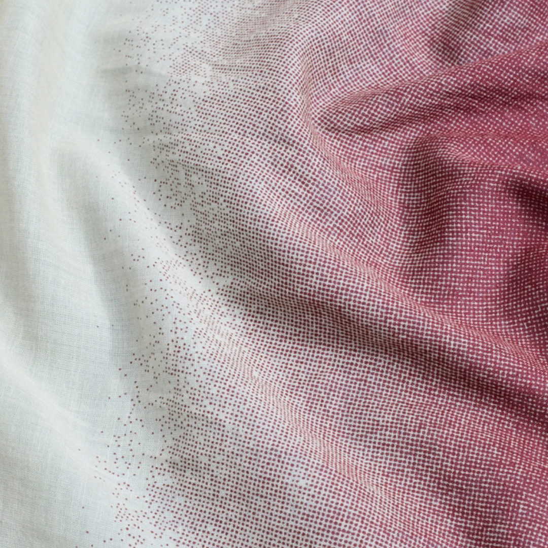 Cream-colored fabric with a gradient of densely packed maroon dots, increasing in concentration from left to right.