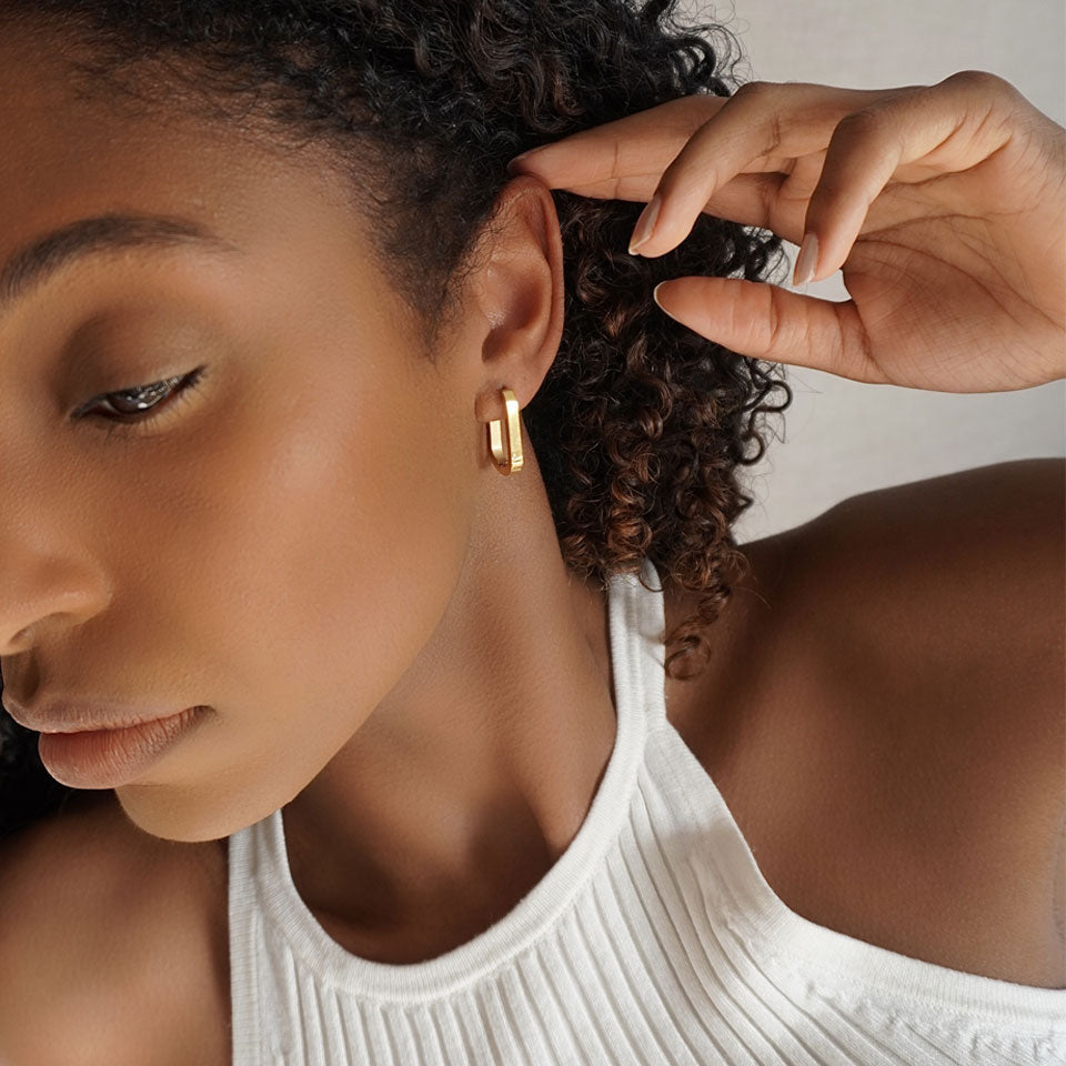 Gold, rectangular hoop earrings. Subtle, minimalist design.