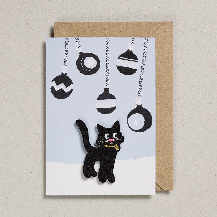 Greeting card with a black cat and Halloween decorations on a light blue background