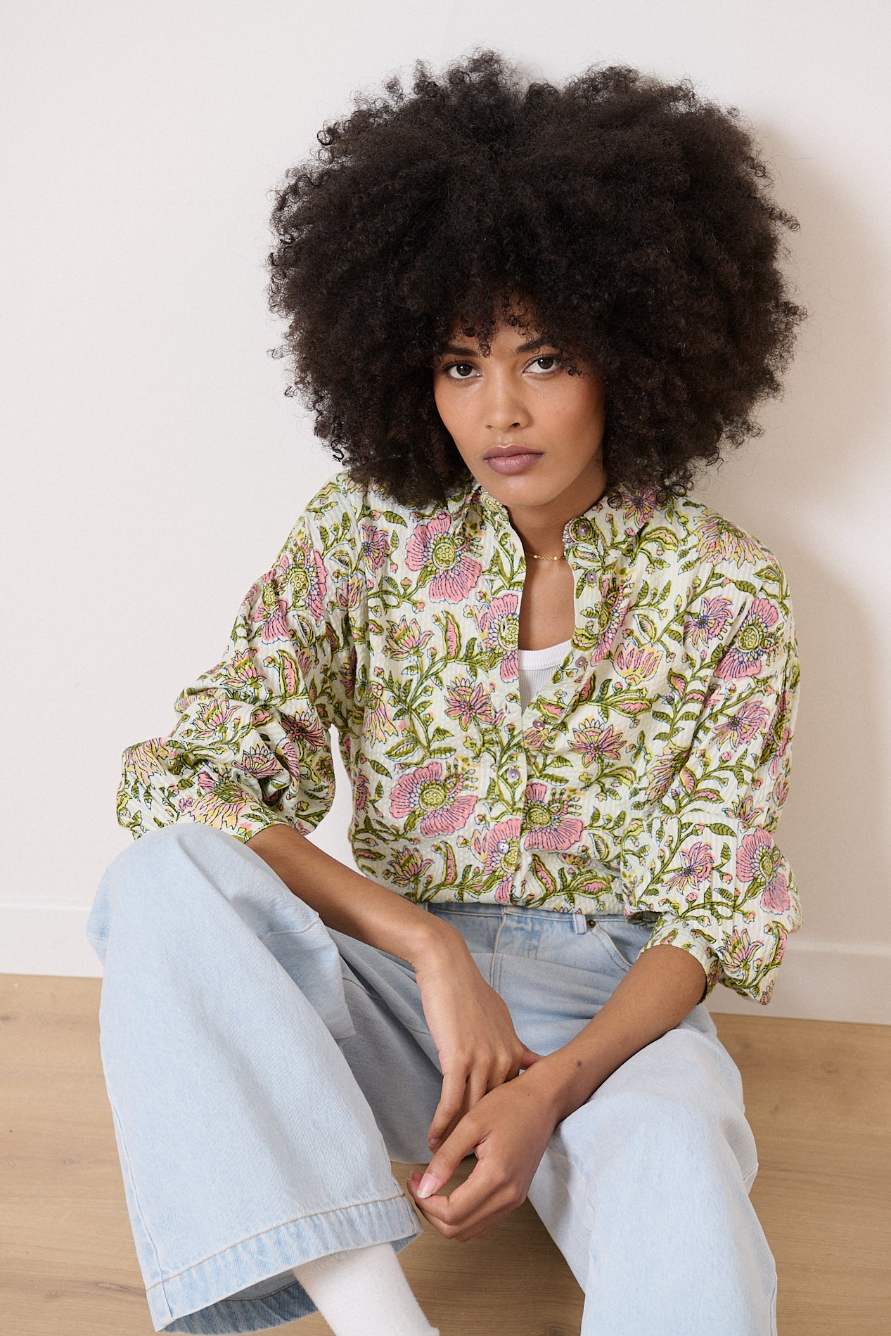 Floral print button-down shirt with long sleeves and a relaxed fit. The shirt is off-white with pink and green flowers.