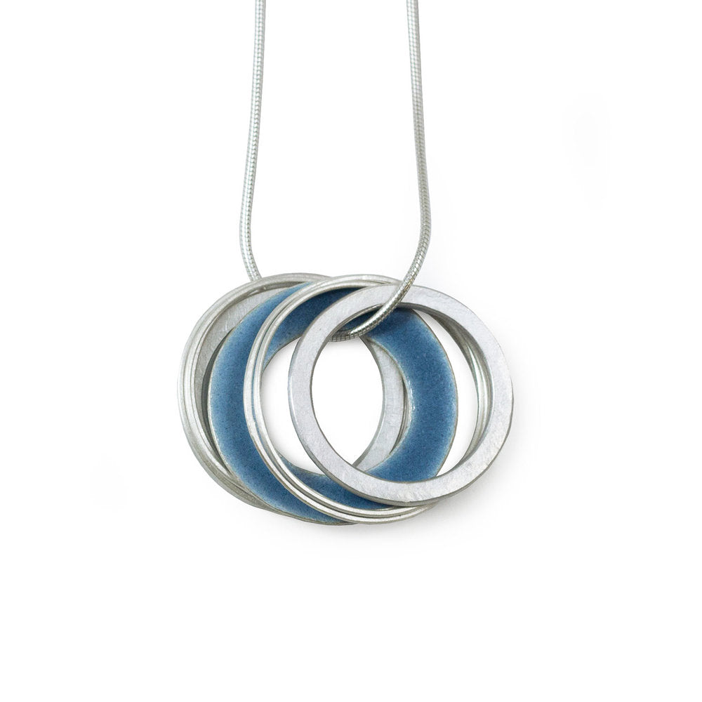 Silver necklace with three interlocking rings; two rings are silver, one has a blue enamel interior.