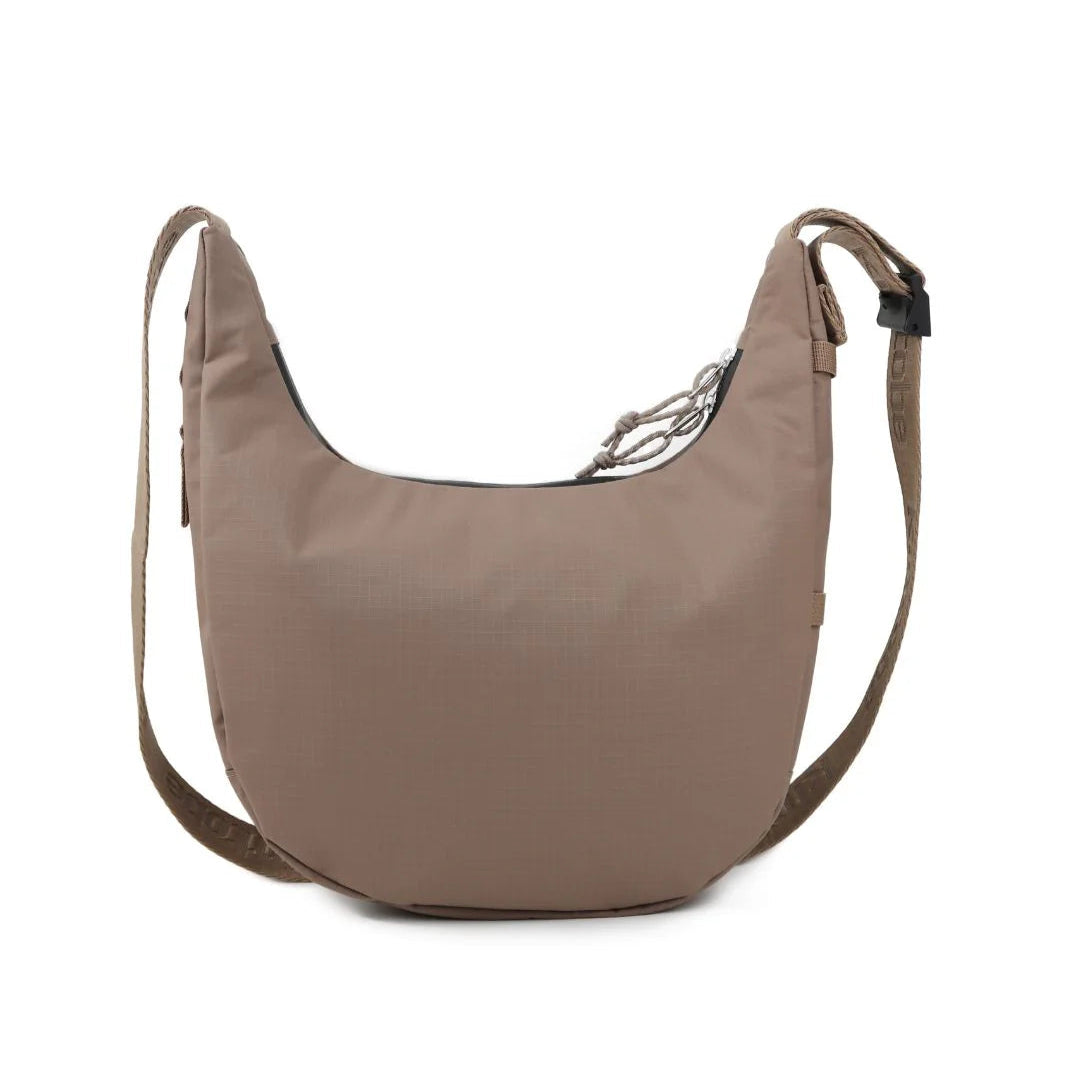 Taupe crossbody bag with a curved silhouette, zipper closure, and adjustable shoulder strap.