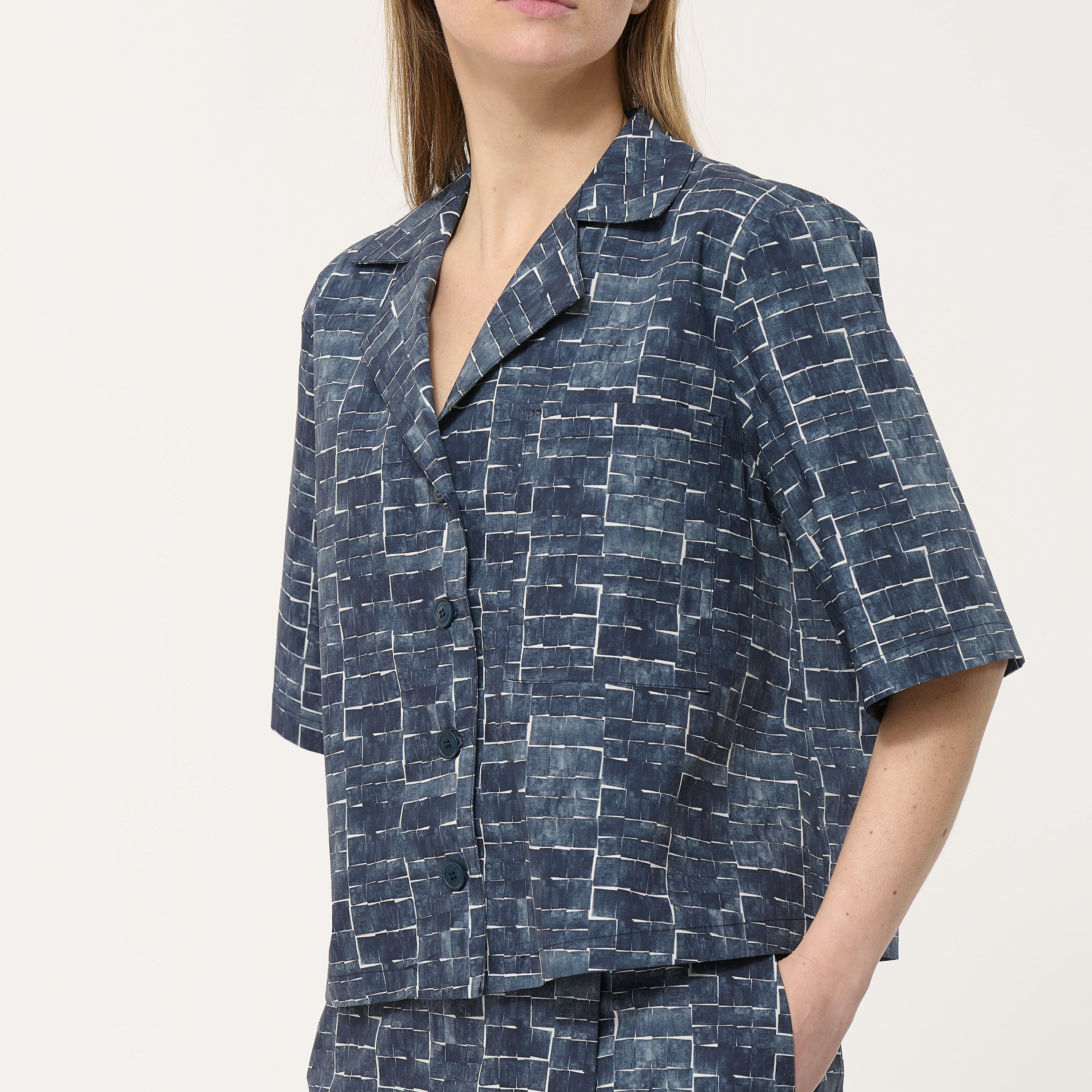 Women's short-sleeved button-down shirt in navy blue with an abstract, geometric print.