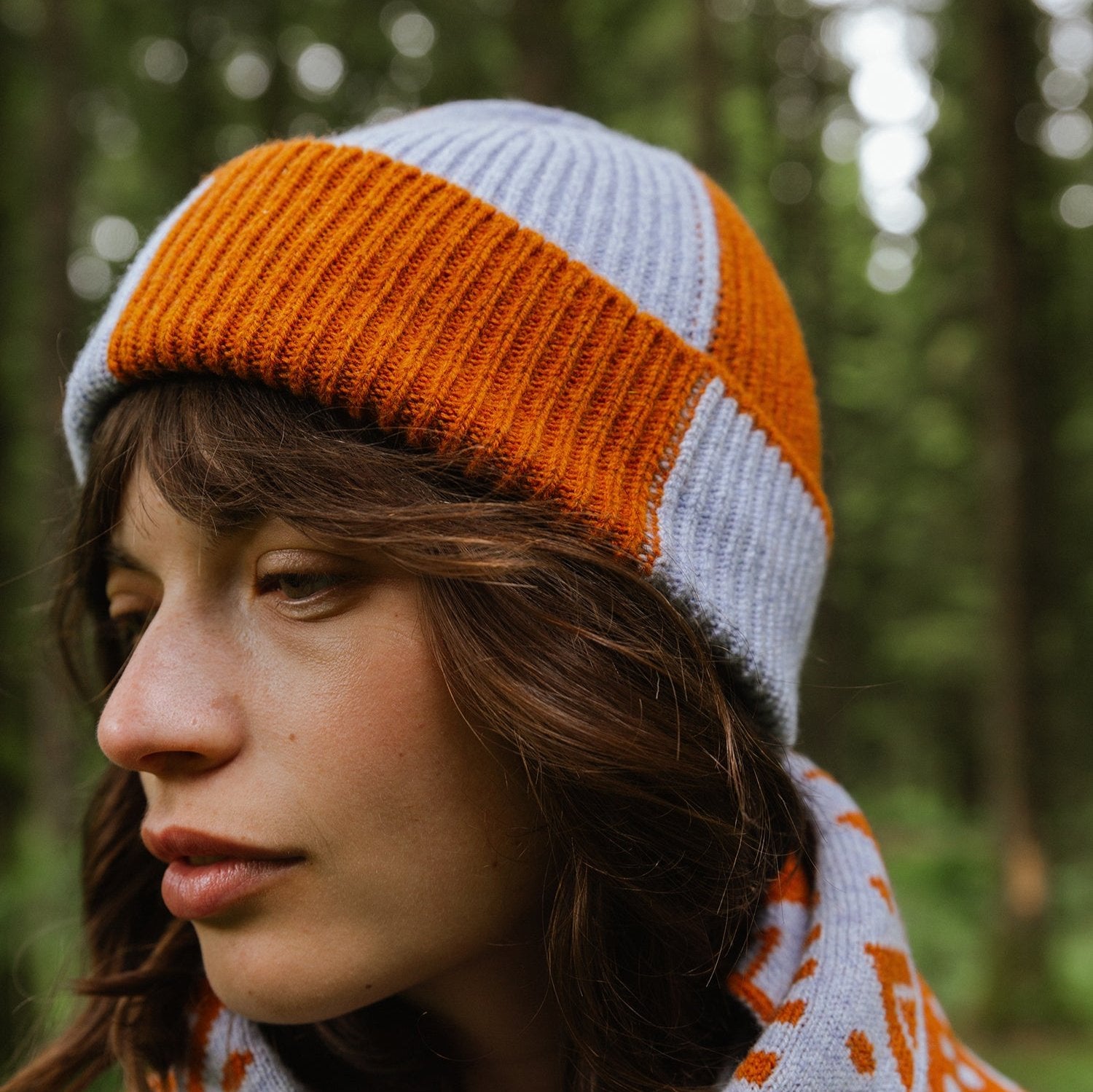 Close-up of a ribbed knit beanie in orange and light purple.
