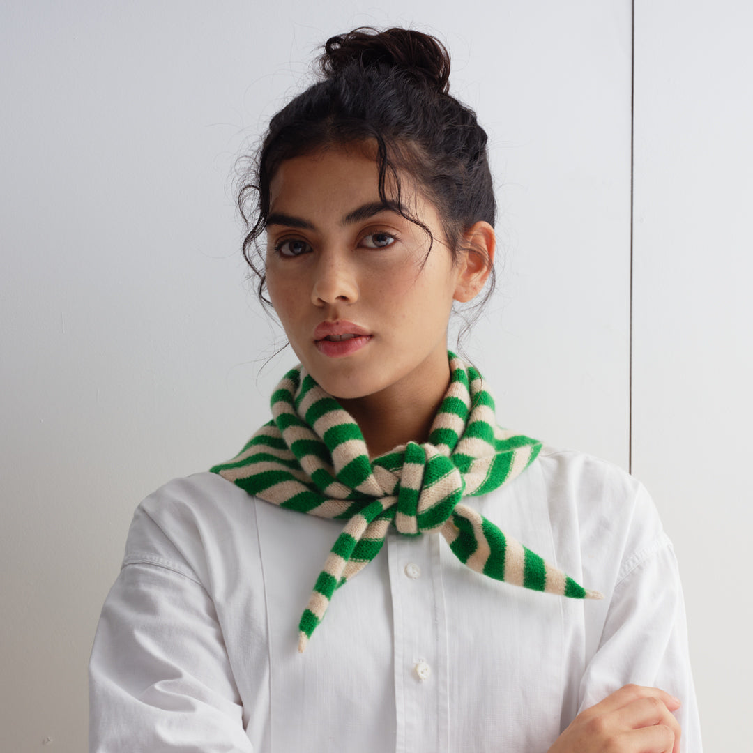 Green and cream striped knit scarf, tied in a knot at the neck.