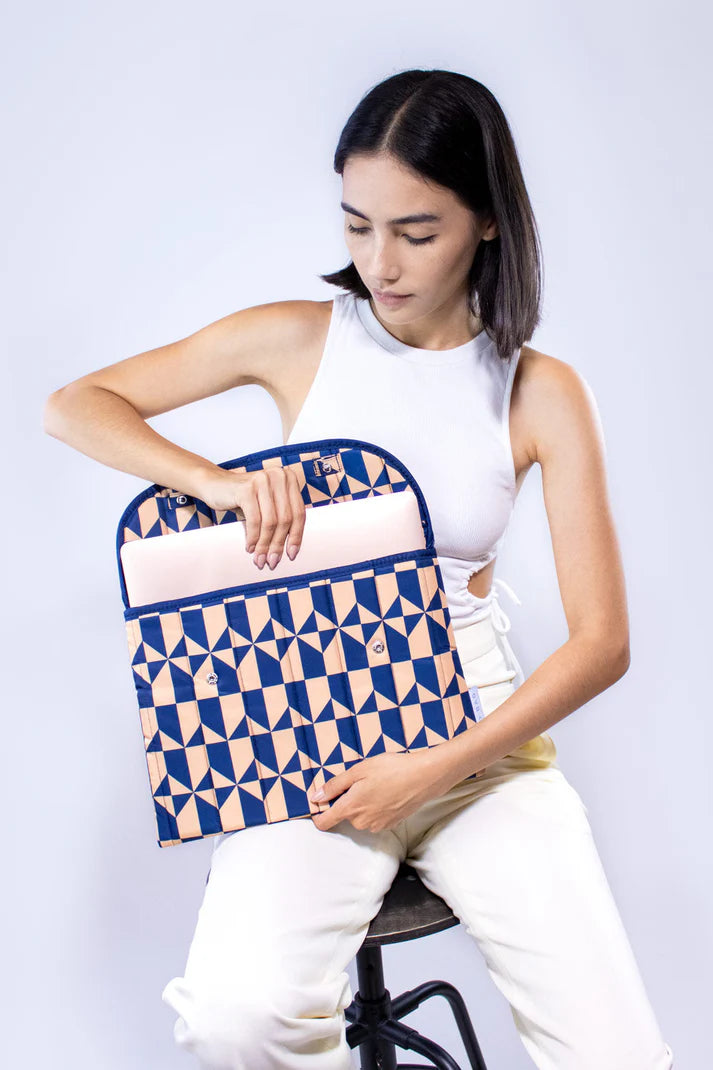 Laptop sleeve with navy and beige geometric pattern.  A laptop is partially visible inside.