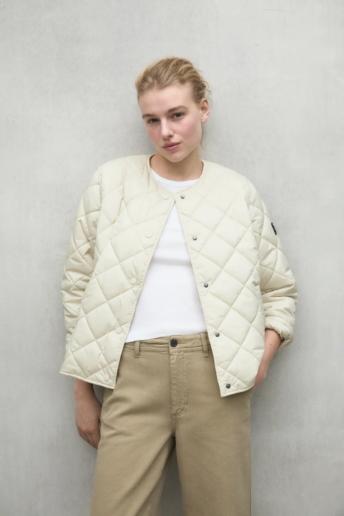 Cream-colored quilted diamond-patterned button-front jacket.