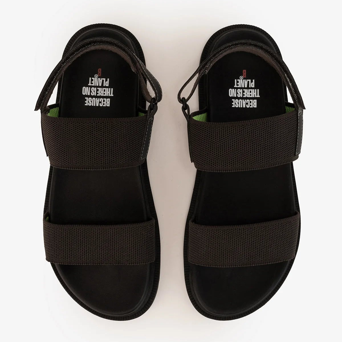 Pair of black sandals with two dark gray fabric straps and a text detail inside the strap: "Because there is no planet".