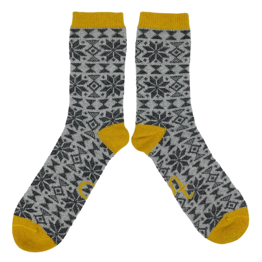 Pair of grey socks with a snowflake pattern and mustard yellow cuffs.