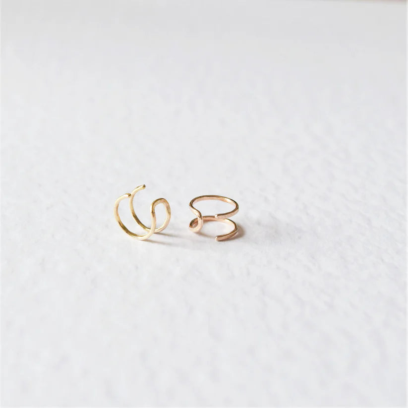 Pair of gold ear cuffs; one has a single, slightly irregular loop, the other is double-looped.