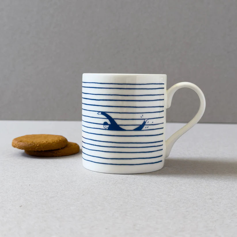 White mug with blue horizontal stripes and a graphic of a person swimming underwater.