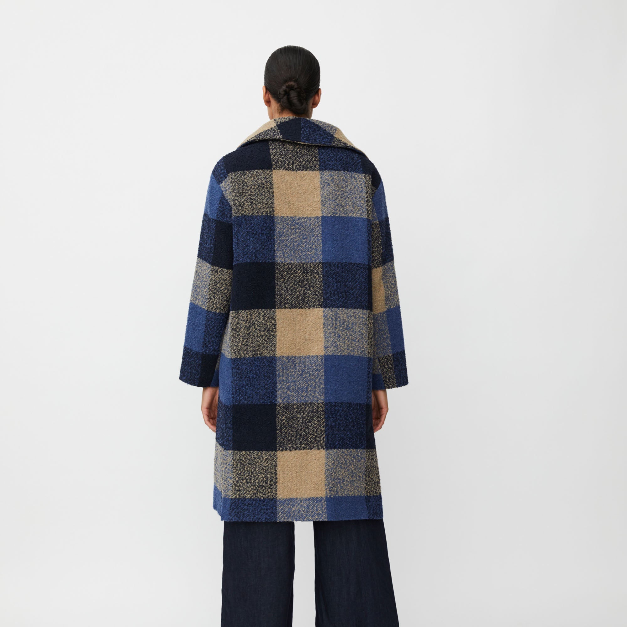 Person wearing a checkered coat on a white background