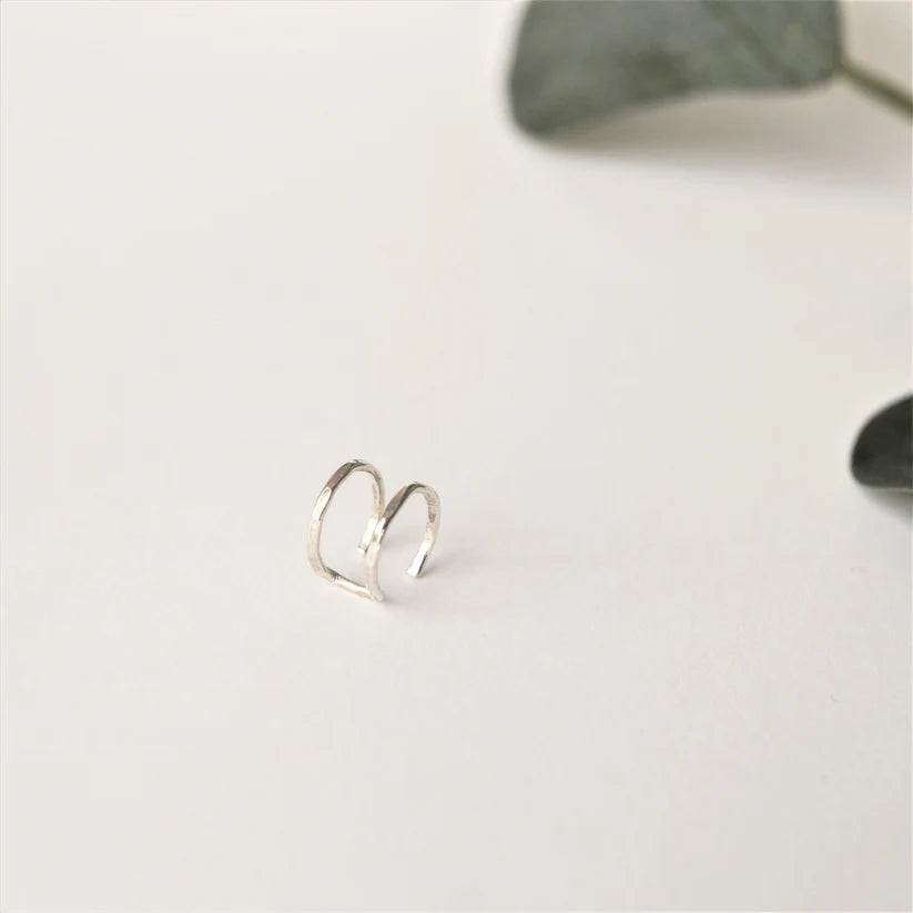 Silver double-hoop ear cuff with hammered texture.