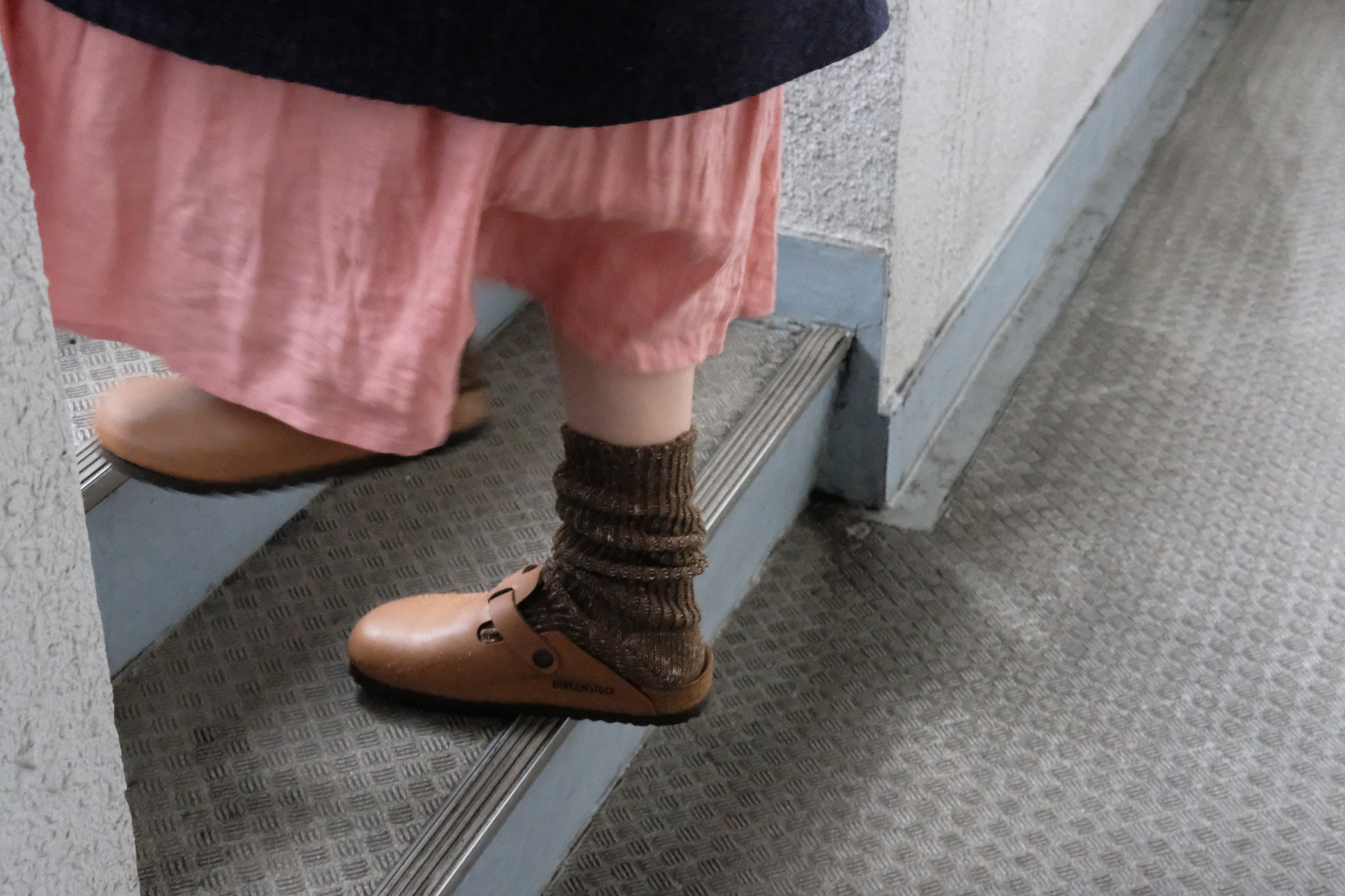 Tan leather Birkenstock clogs worn with brown ribbed socks.