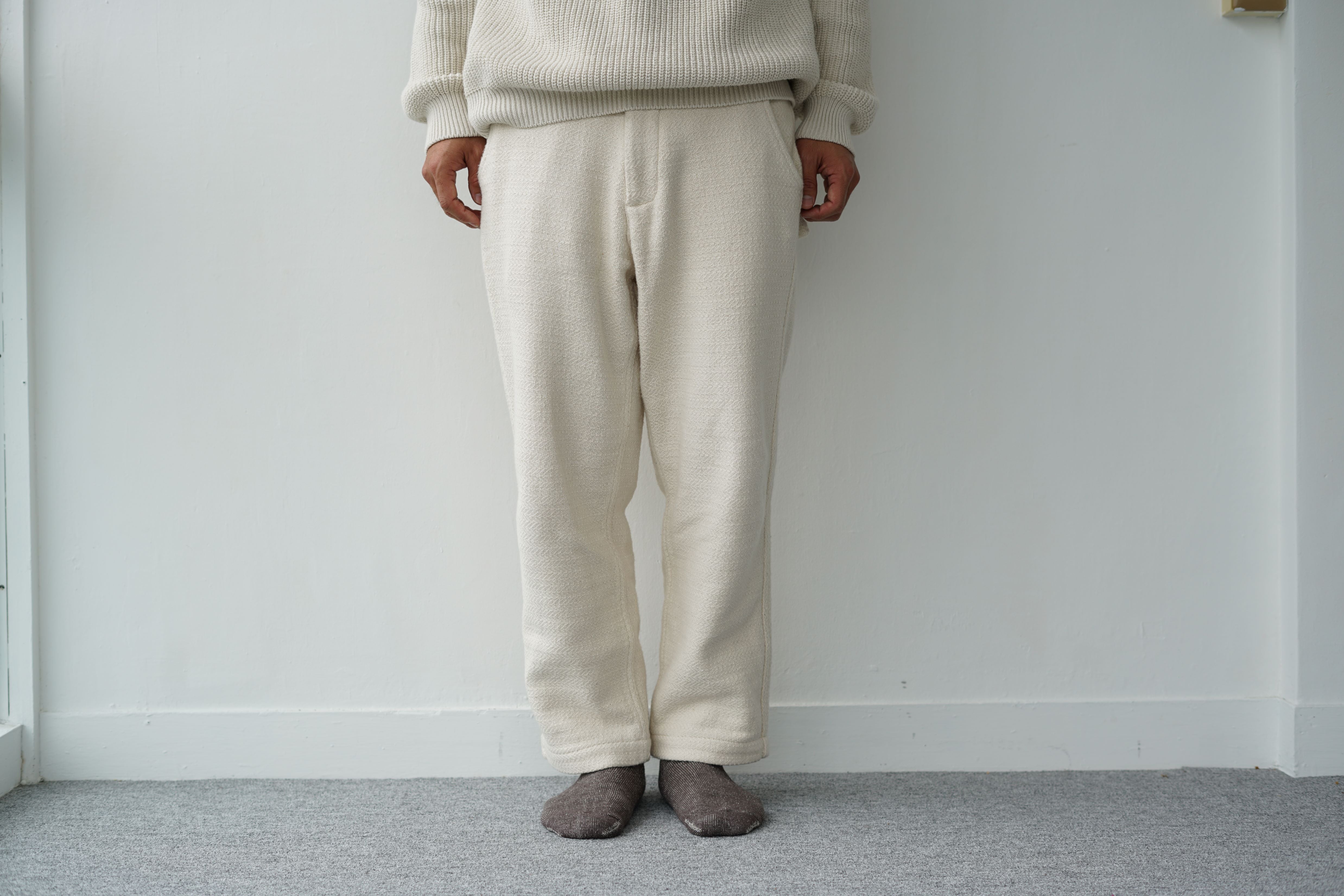 Off-white textured cotton pants, straight-leg fit, shown on a model.