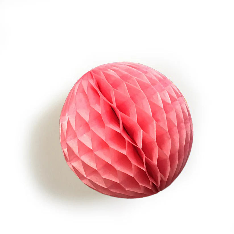Pink honeycomb paper ball decoration. The ball is round and features a textured, folded design.