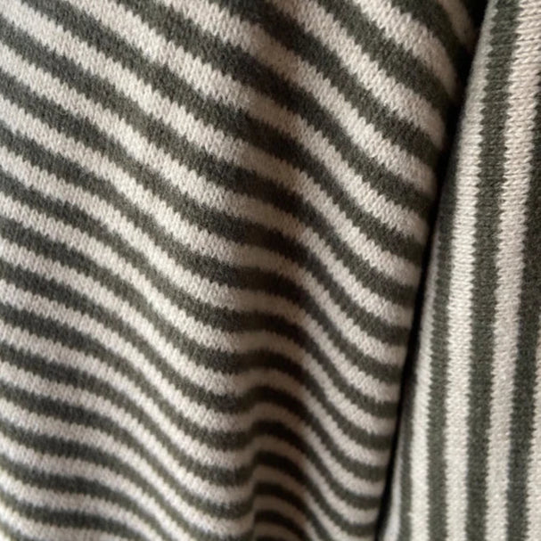 Close-up of olive green and off-white horizontally striped knit fabric.