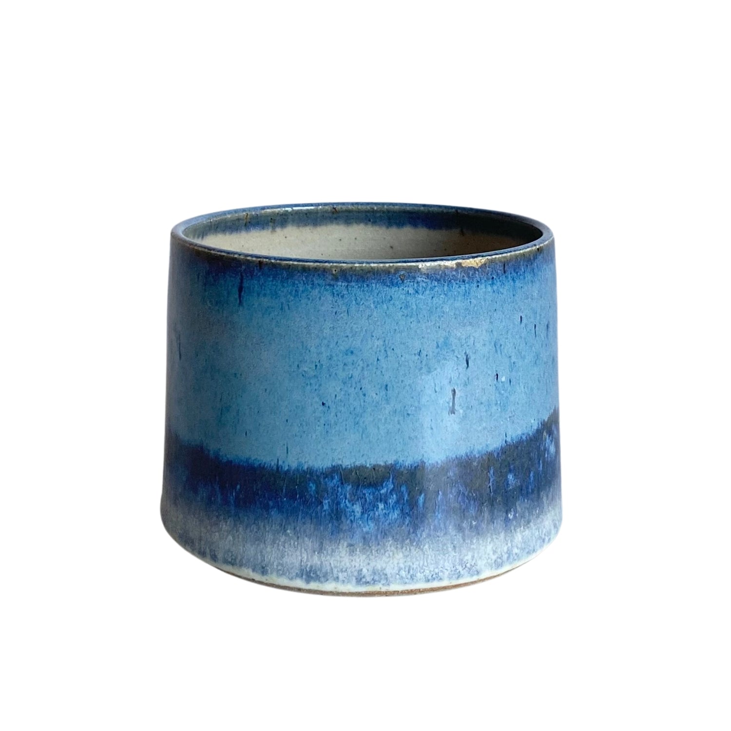 Cylindrical ceramic bowl with a gradient of blue glaze, transitioning from light to dark blue at the base.