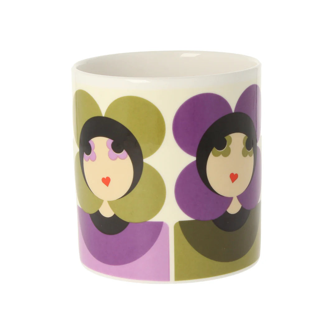 Ceramic mug with colorful abstract face design on a white background
