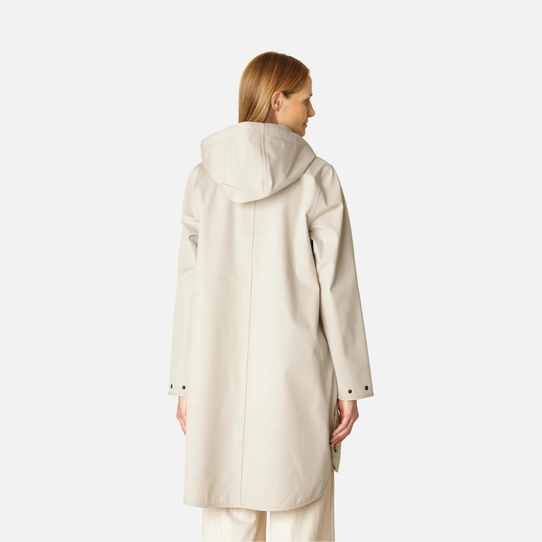 Beige hooded raincoat, rear view, showing smooth matte texture and simple design. Long sleeves, buttoned cuffs.