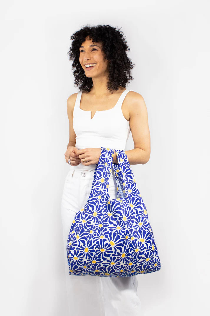 Reusable shopping bag with a blue and yellow floral pattern.