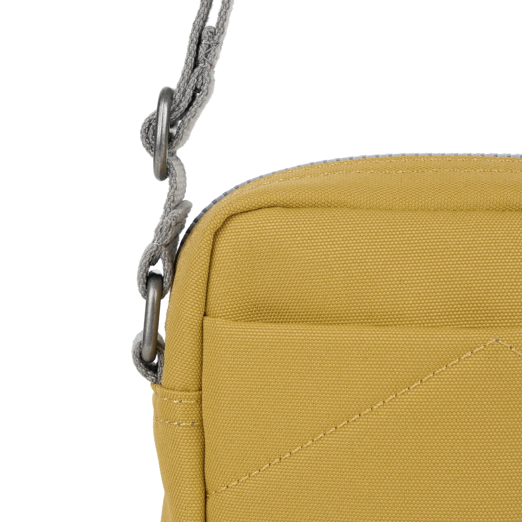 Mustard yellow canvas crossbody bag with gray braided strap and metal hardware.