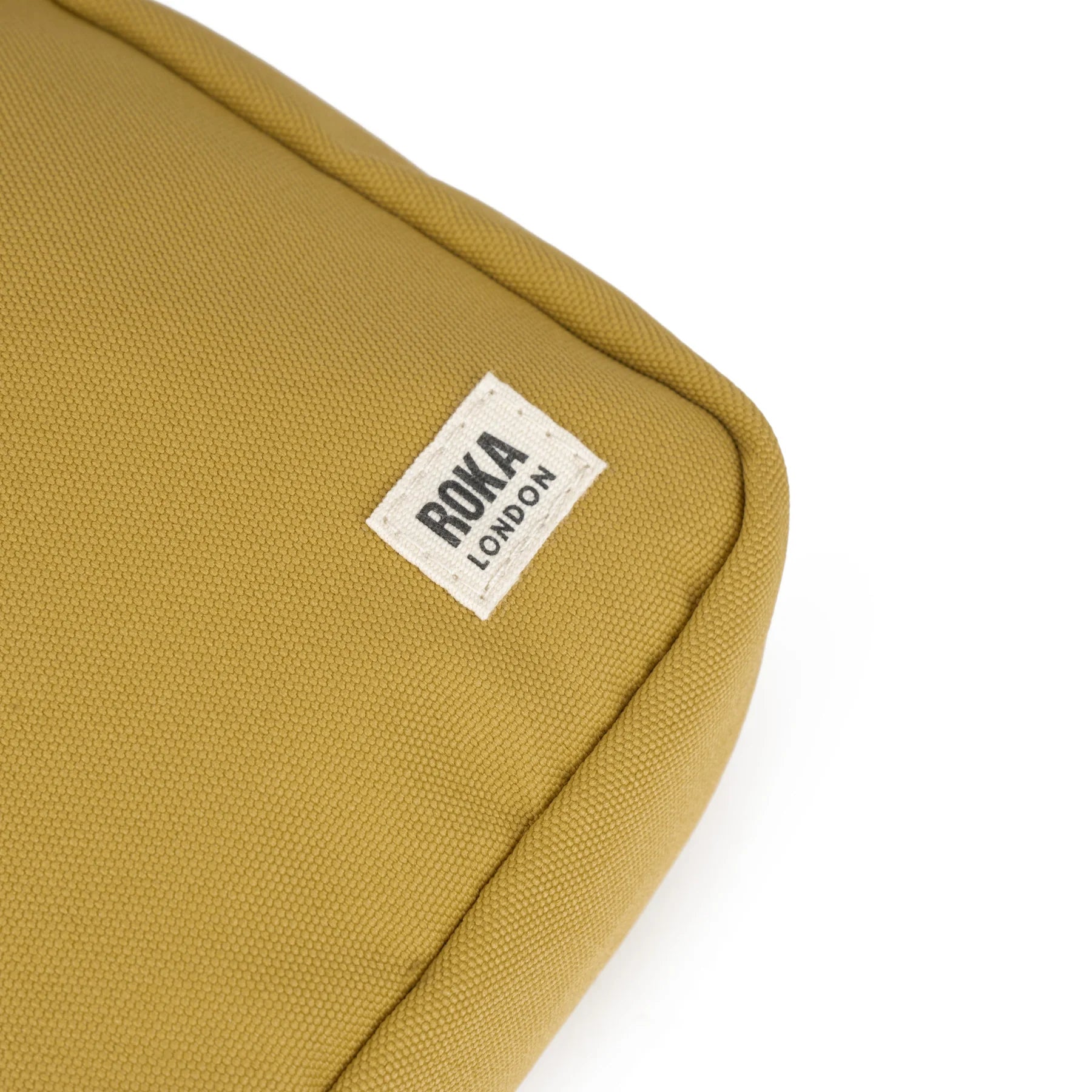 Mustard yellow canvas bag with a "ROKA LONDON" label.