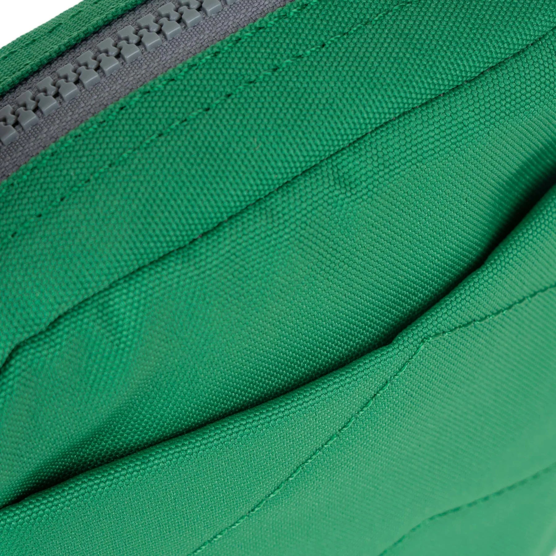 Close-up of a vibrant green zippered pouch or bag, showcasing its textured fabric and gray zipper.