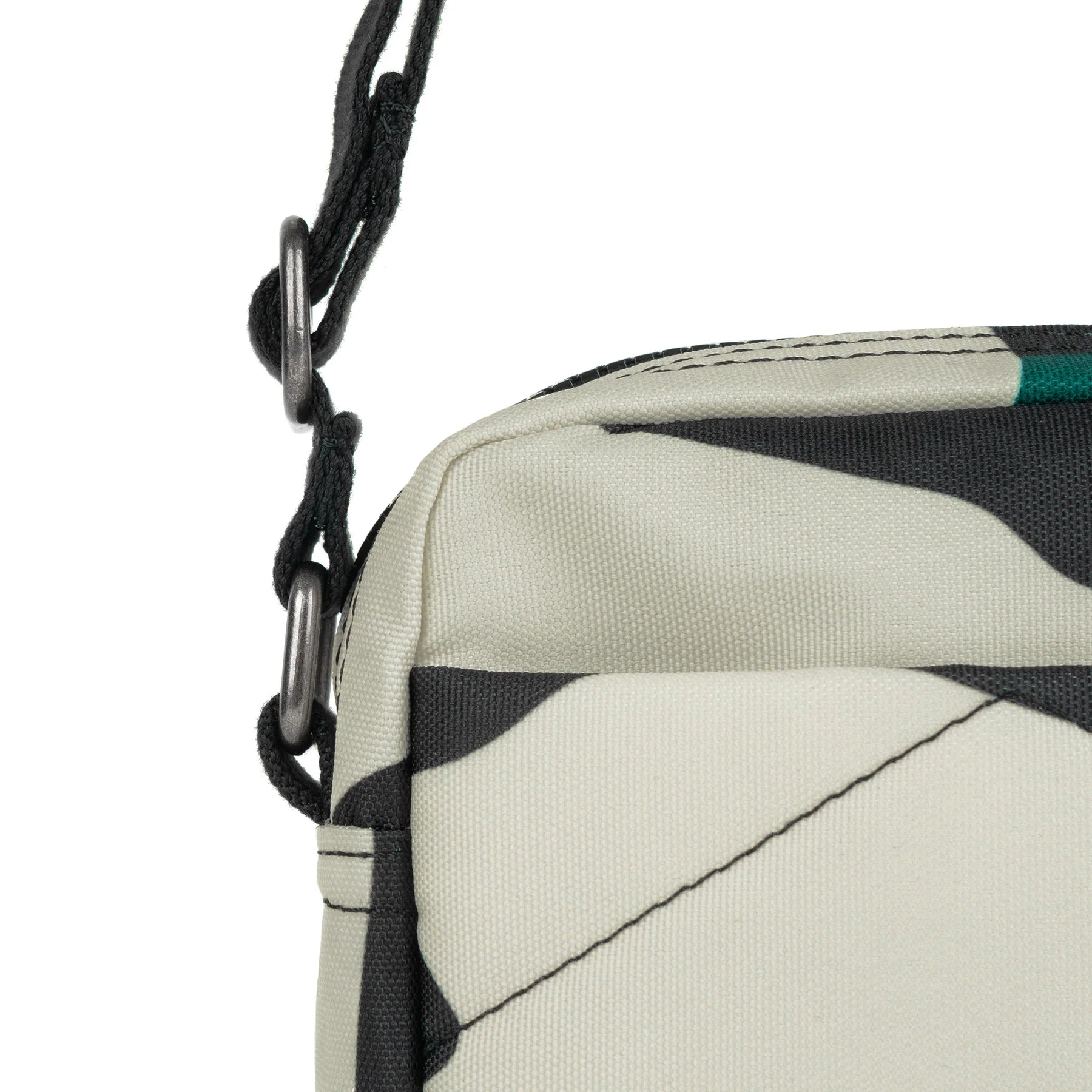 Close-up of a beige and black patterned crossbody bag with a black shoulder strap and silver-toned hardware.