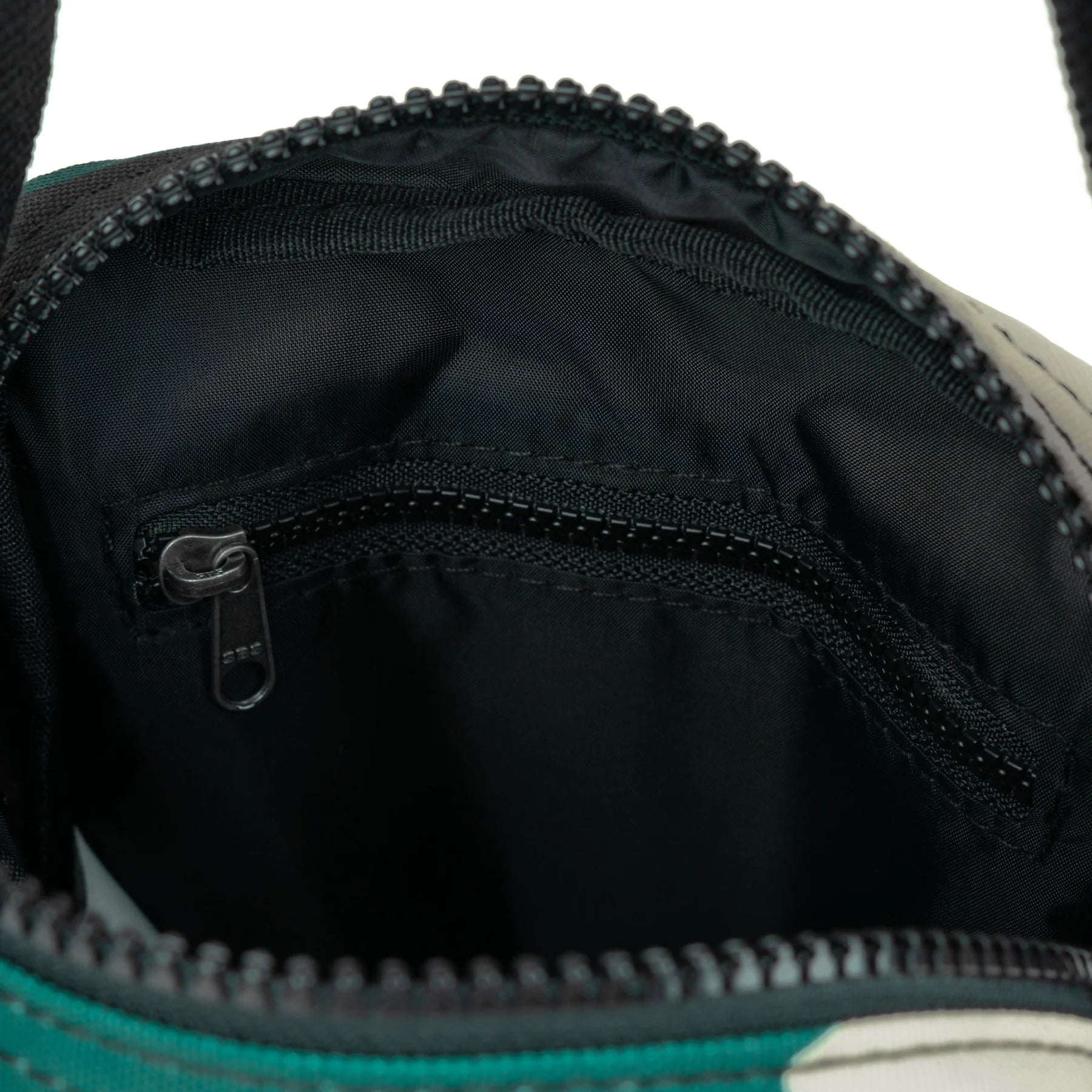 Teal and gray zippered bag interior showing black fabric lining and a smaller zippered pocket.
