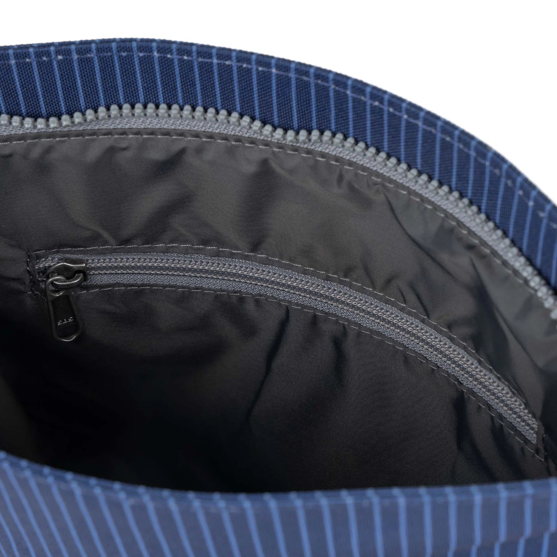 Blue striped fabric bag interior, showing dark gray lining, zipper closure, and small interior zippered pocket.