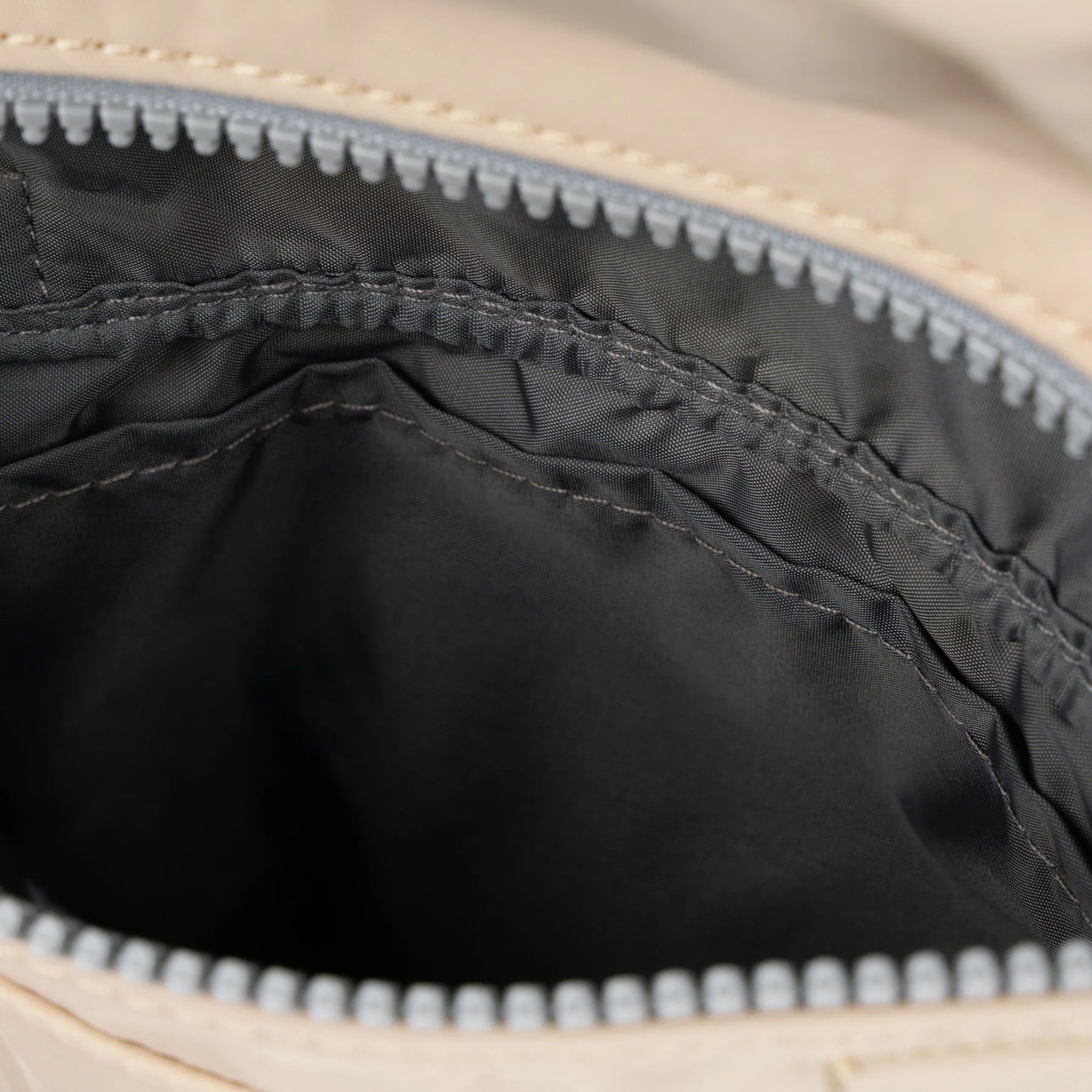 Close-up of the interior of a ROKA bag, featuring a gray lining and zip closure.