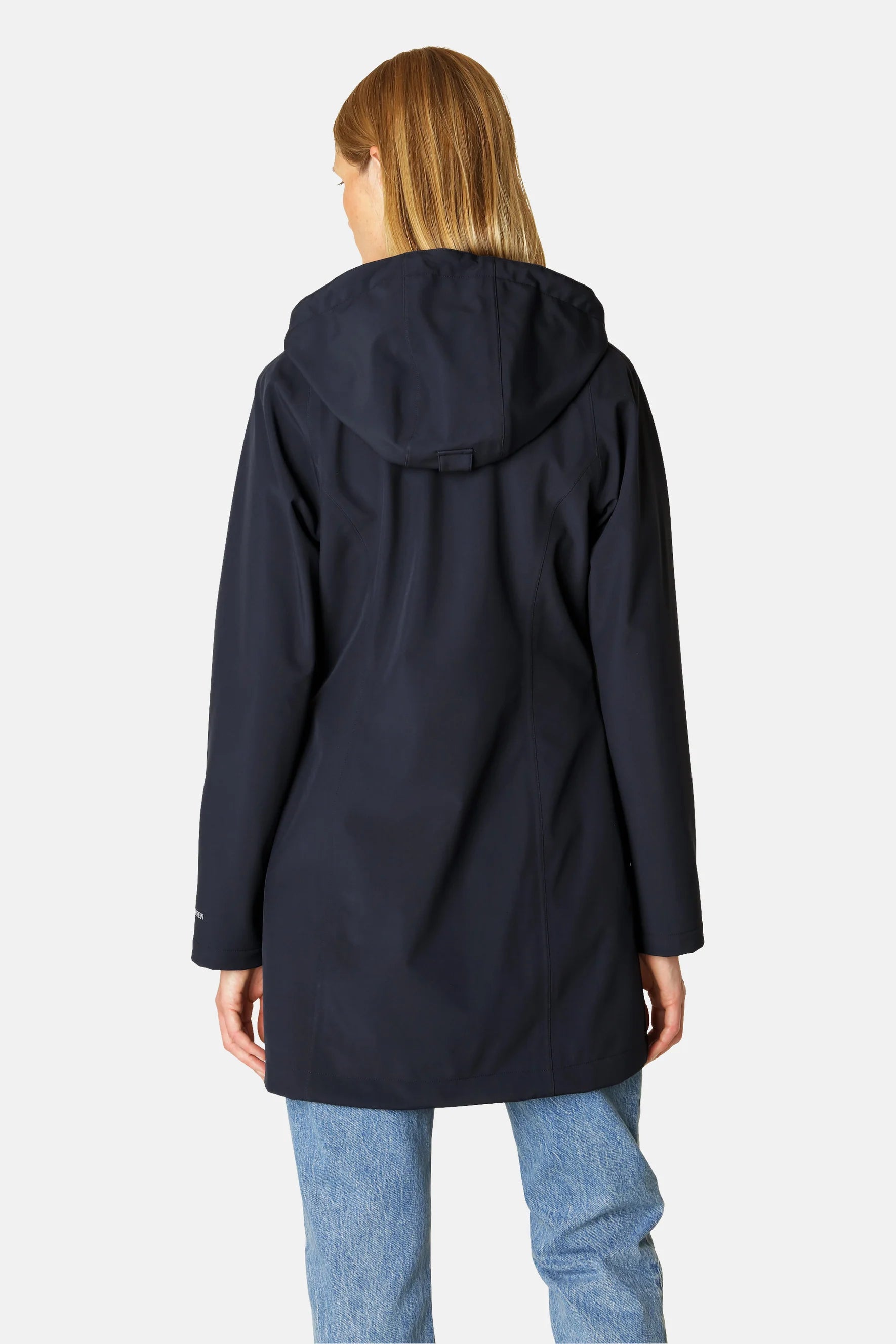 Rear view of a woman wearing a navy blue, hooded, knee-length softshell jacket. Smooth, matte texture. The jacket has a simple