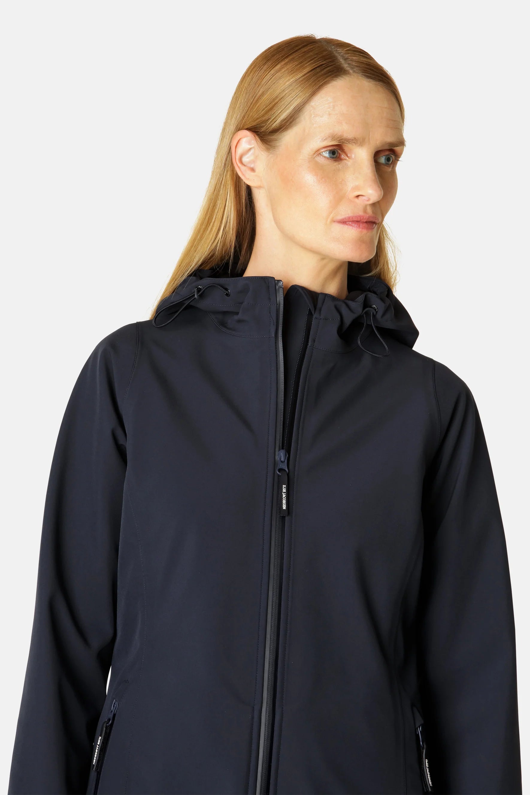 Navy blue softshell jacket with a hood and zipper closure. The jacket is smooth and appears lightweight. A subtle brand logo is