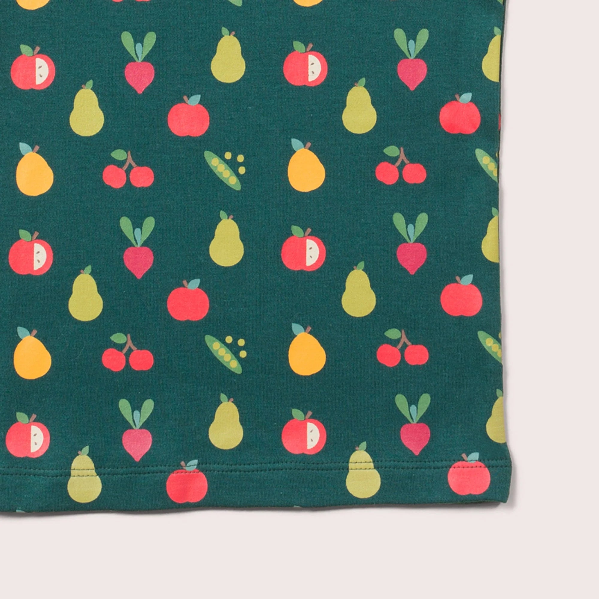 Dark green fabric with a repeating pattern of illustrated apples, pears, cherries, and beets.