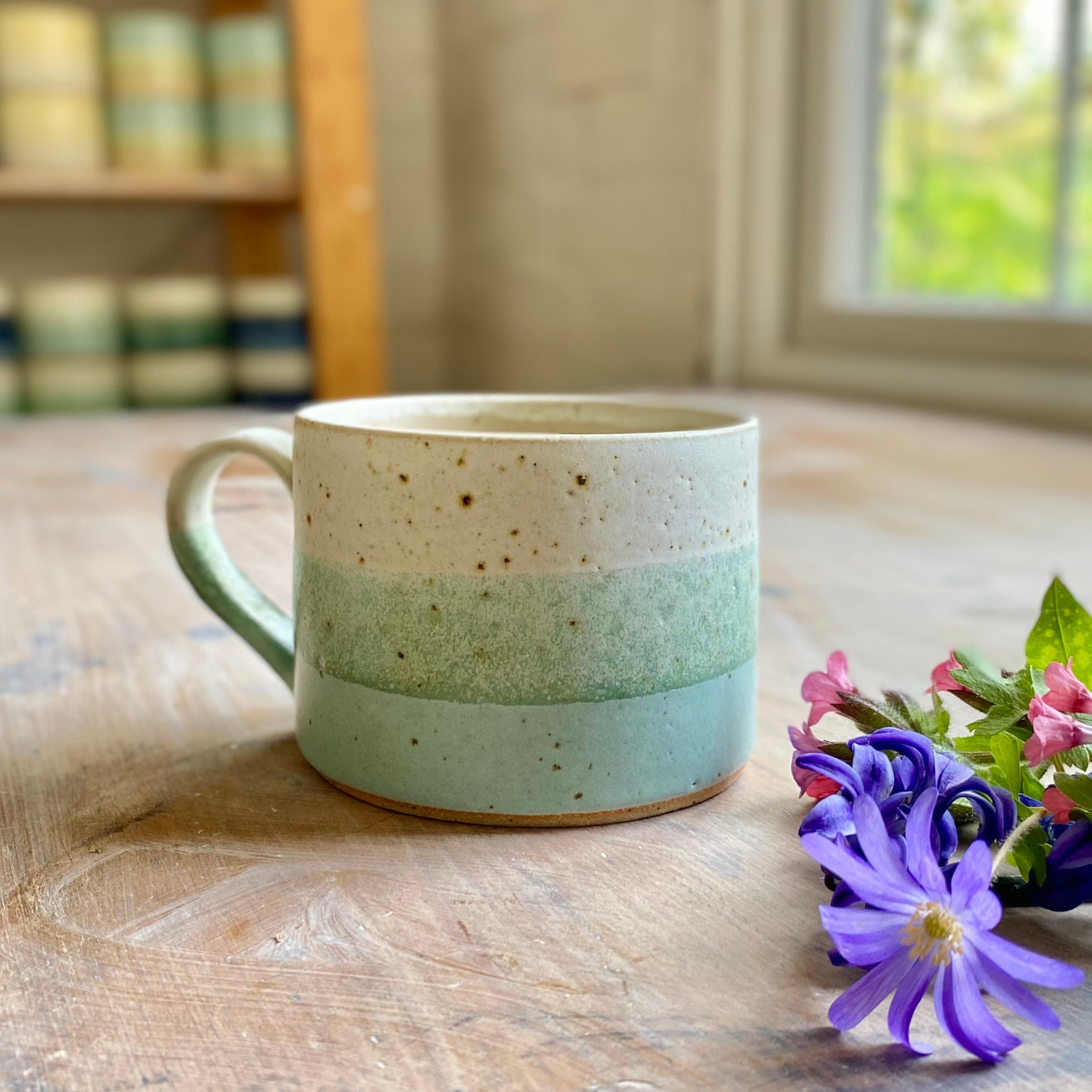 Stoneware mug with speckled off-white, light green, and seafoam green horizontal bands.
