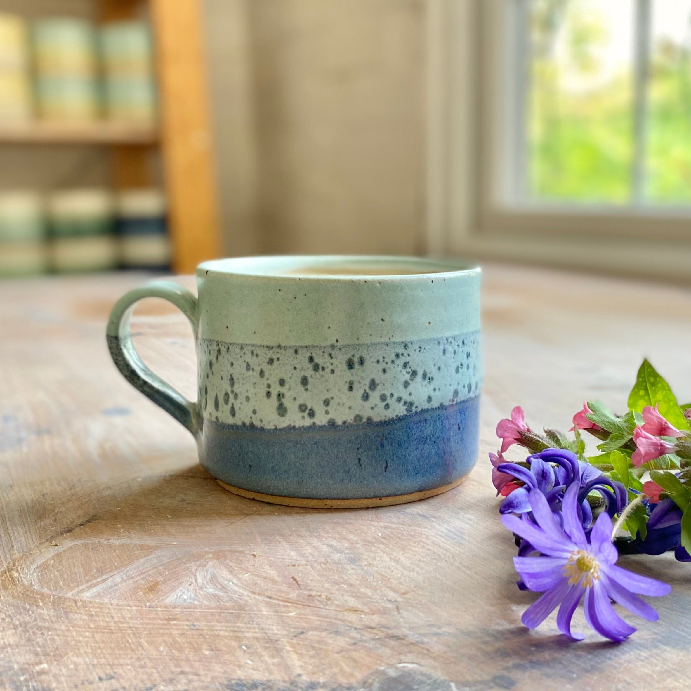 Hand-thrown stoneware mug with a speckled light blue and dark blue glaze.