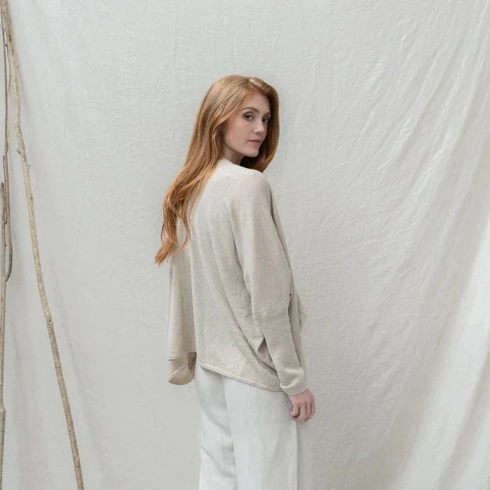 Beige linen knit cardigan with a draped, asymmetrical hem.