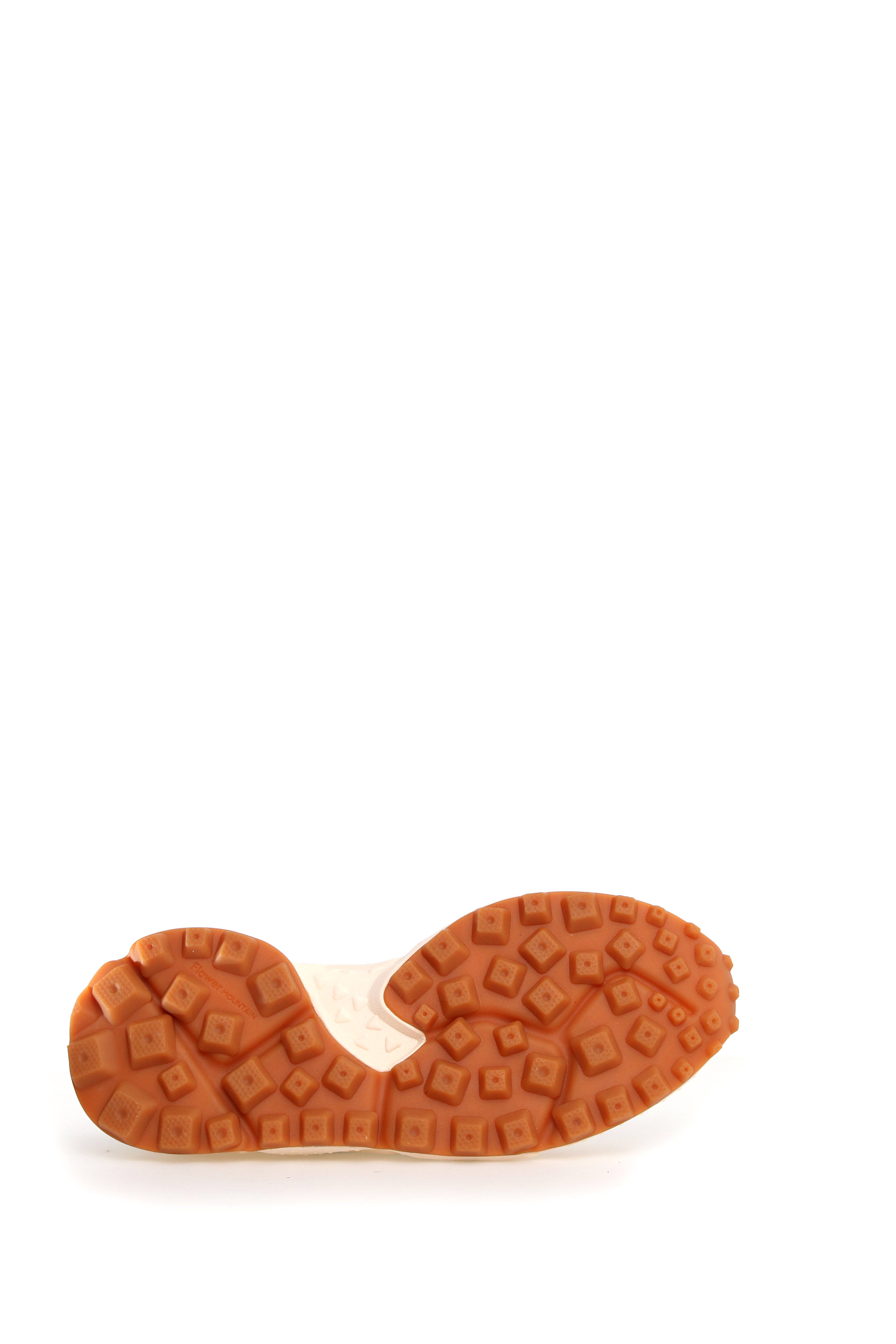 Off-white sneaker sole with a textured, brown rubber outsole featuring a repeating square pattern.