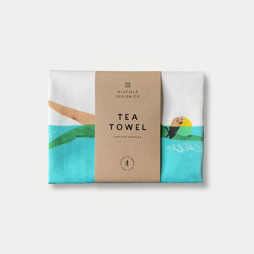 Cotton canvas tea towel featuring an illustration of a person swimming in turquoise water.