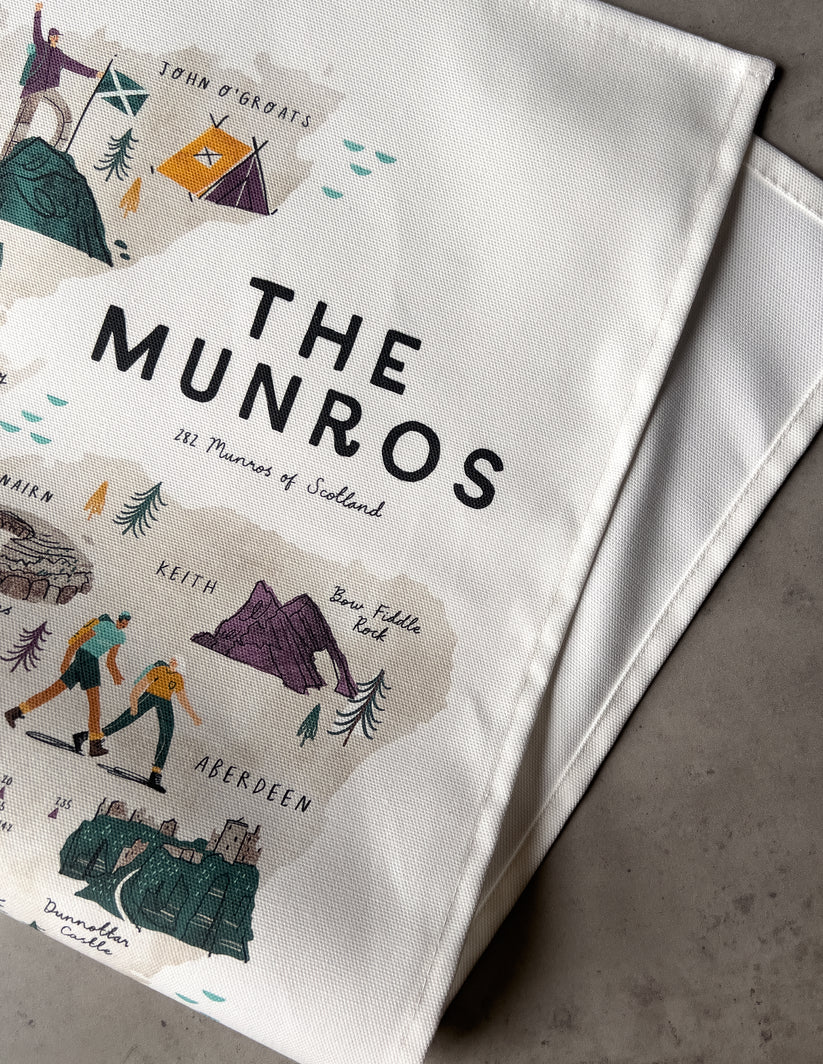 Off-white cotton tea towel featuring an illustrated map of Scotland's Munros, including landmarks and hikers.