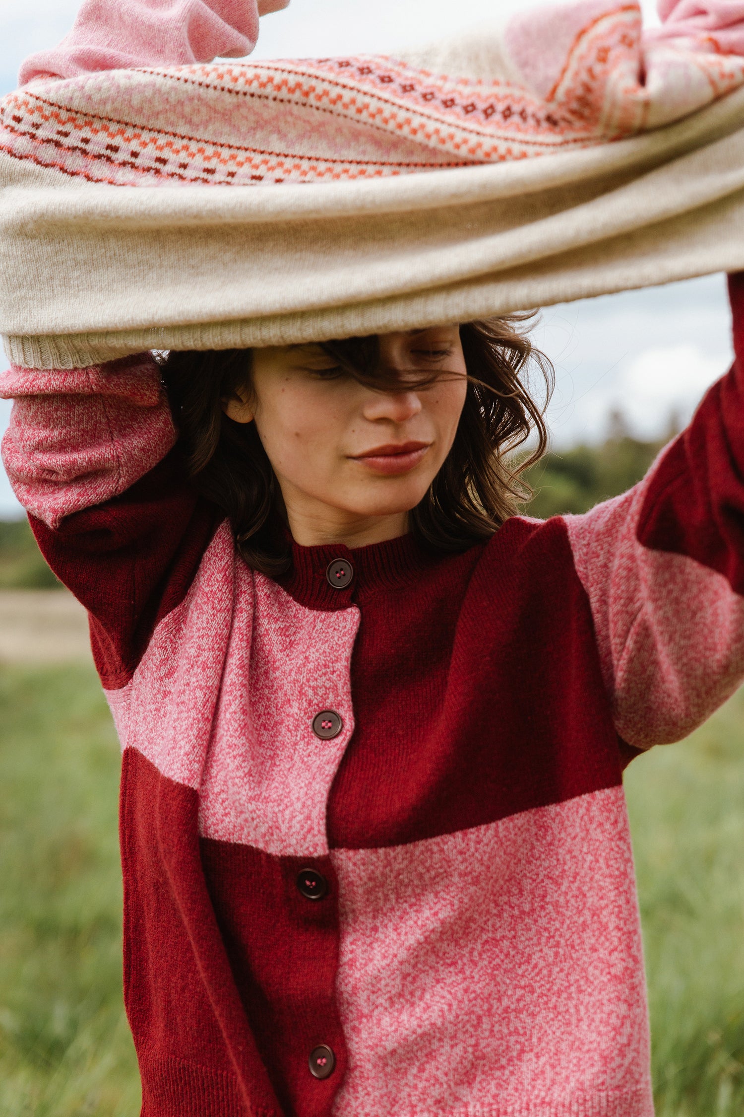 Color-blocked wool cardigan in burgundy and pink, featuring a Fair Isle-patterned section.  The cardigan is button-front.