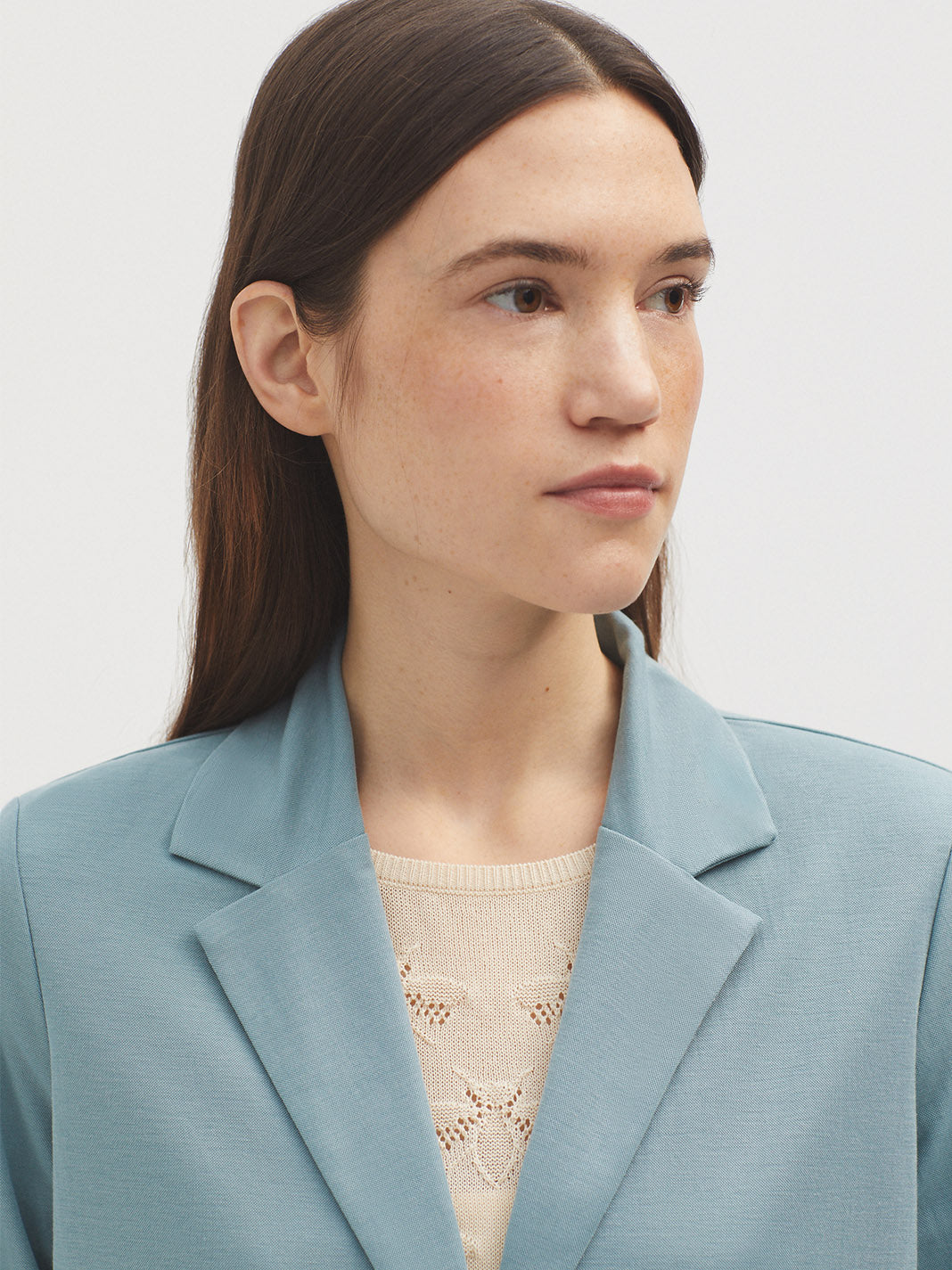 Dusty blue blazer with notched lapels, shown on a model.