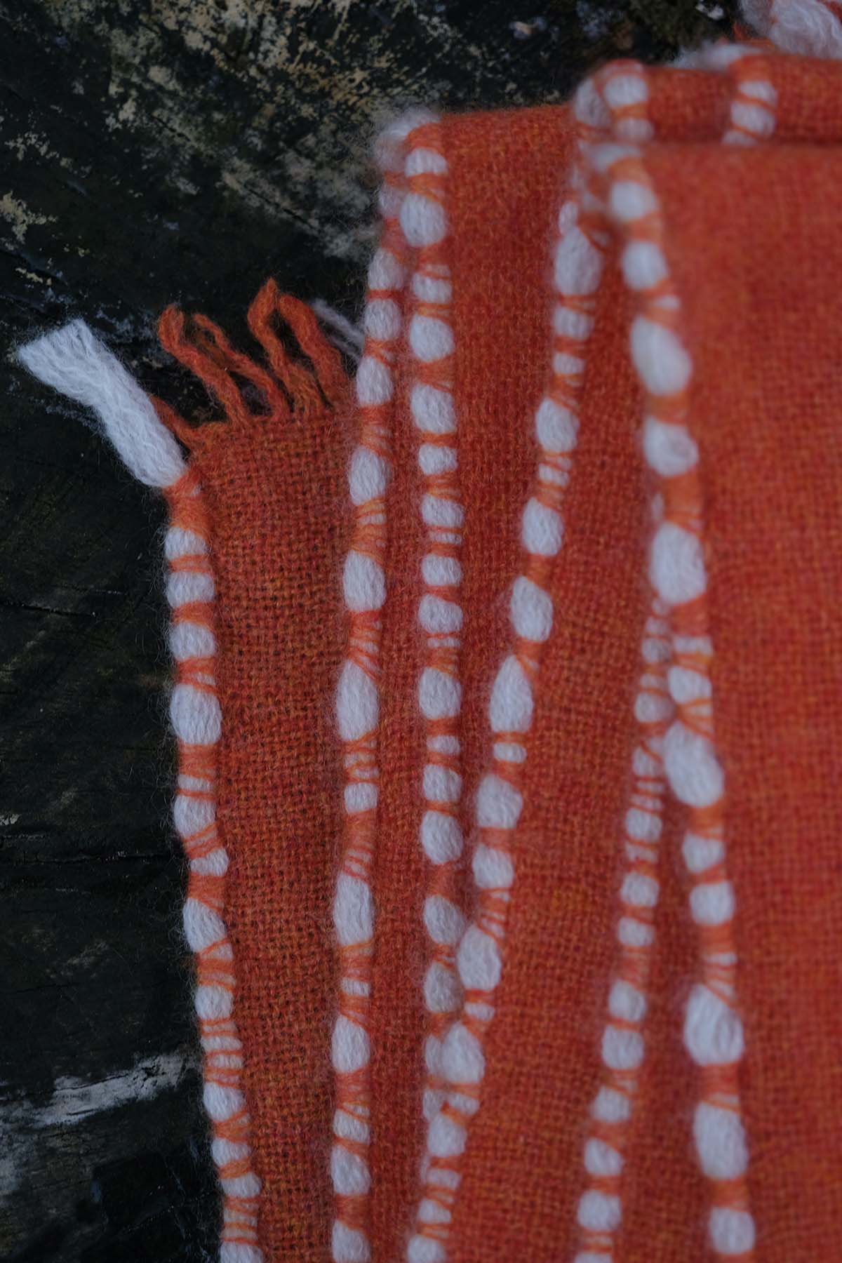 Close-up of an orange towel with white patterns on a dark background
